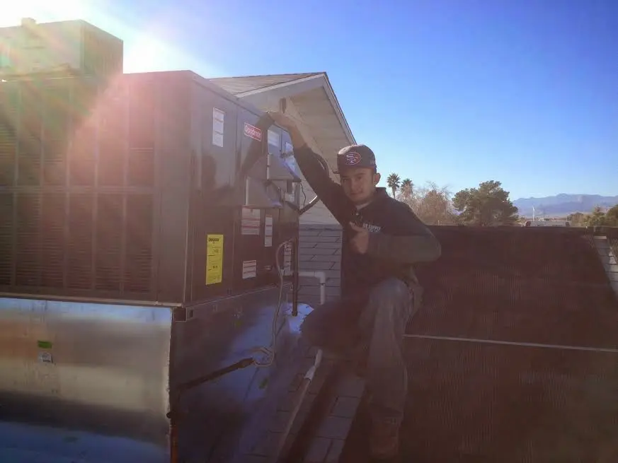 HVAC technician performing AC Tune-Up on a rooftop unit in Sumpter